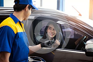 Asian lady got a key from technician after checked her car in car  service center