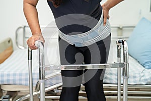 Asian lady patient wearing back pain support belt for orthopedic lumbar with walker