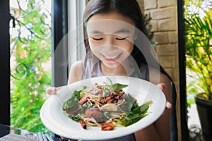 Asian lady show spagetti with Thai food topping in restautant