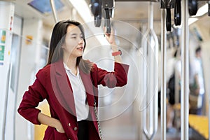 Asian lady stand on the train to go to her office