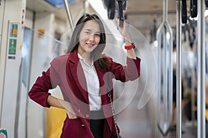 Asian lady stand on the train to go to her office