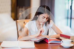 Asian lady student read a text book for prepare to examination o