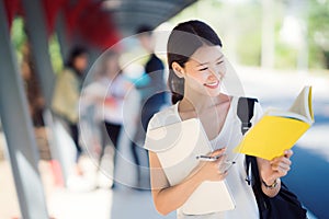 Asian lady student in university walking in walk way