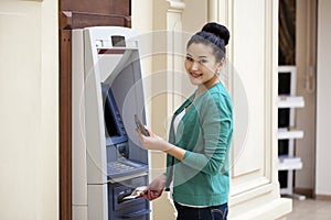 Asian lady using an automated teller machine