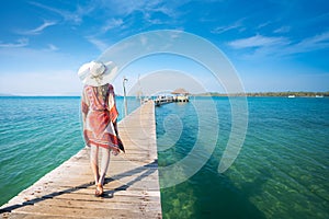 Asian lady walk in wooded bridge to harbor in Koh Mak