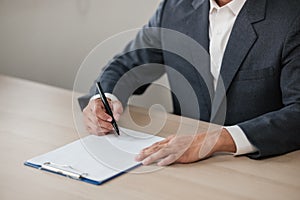 Asian lawyer man working on table office Writing a document, law and justice concept.