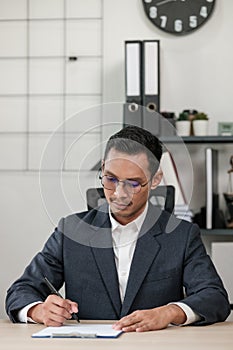 Asian lawyer man working on table office Writing a document, law and justice concept.