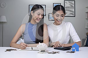 Asian lesbian couple holding credit card and using laptop computer. LGBT lesbian businesswoman working at home. Online shopping