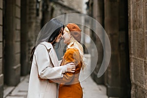 Asian lesbian couple smiling while standing close to each other.