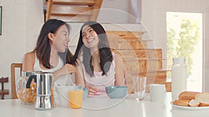 Asian Lesbian lgbtq women couple have breakfast at home, Young Asia lover female feeling happy drink juice, cornflakes cereal and