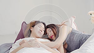 Asian Lesbian lgbtq women couple wake up at home. Young Asia lover female happy relax rest together after sleep all night on bed