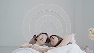 Asian Lesbian lgbtq women couple wake up at home. Young Asia lover female happy relax rest together after sleep all night on bed