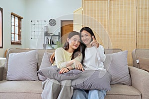 Asian lesbian woman couple enjoy watch TV together in house and feel happy watch movie on television. Homosexual-LGBTQ