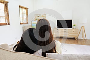 Asian lesbian woman couple enjoy watch TV together in house and feel happy watch movie on television. Homosexual-LGBTQ