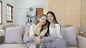 Asian lesbian woman couple enjoy watch TV together in house and feel happy watch movie on television. Homosexual-LGBTQ