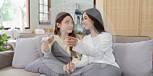 Asian lesbian woman couple enjoy watch TV together in house and feel happy watch movie on television. Homosexual-LGBTQ