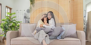 Asian lesbian woman couple enjoy watch TV together in house and feel scared watch movie on television. Homosexual-LGBTQ