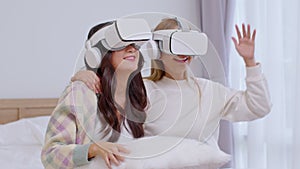 Asian LGBT couple singing and dancing with VR virtual reality glasses headset dancing in metaverse world together. Lesbian women