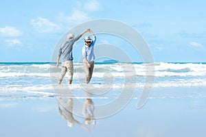 Asian Lifestyle senior couple dancing on the beach happy and relax time.