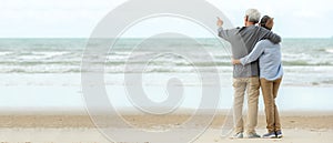 Asian Lifestyle senior couple hug and pointing on the beach happy in love romantic and relax time.