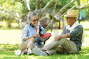 Asian Lifestyle senior couple surprise gift for special day  in the nature park happy and relax time.