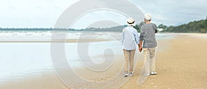 Asian Lifestyle senior couple walking chill on the beach happy in love romantic and relax time after retirement.