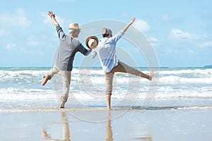 Asian Lifestyle senior couple walking chill and jumping on the beach happy