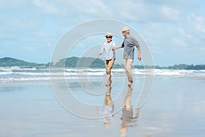 Asian Lifestyle senior elderly couple running on the beach happy enjoy in love romantic and relax time.