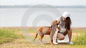 Asian lifestyle woman playing with dog golden retriever friendship so happy and relax outdoor the summer field meadow park.