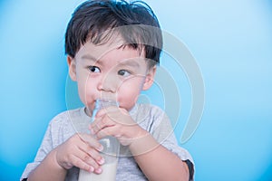 Asian little baby child boy about 2 year drinking milk from bottle glass