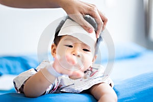 Asian little baby sick with cool fever jel pad on forehead