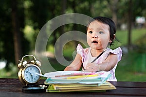 Asian little baby toddler drawing at park while looking at empty space copy sace photo
