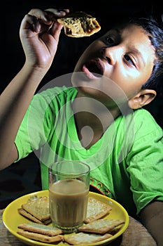 Asiático pequeno chico comer galleta taza té 