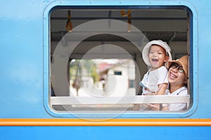 Asian little boy and mother Laughing while traveling by train