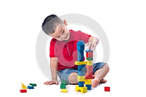 Asian little boy playing with colorful blocks, isolated on white