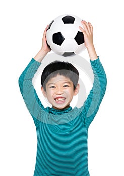 Asian little boy raise soccer ball up