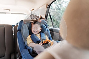 Asian little boy in safety car seat