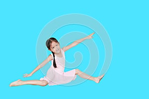 Asian little child girl dancer ballet ballerina stretching isolated on cyan background. Beautiful children in pink tutu skirt