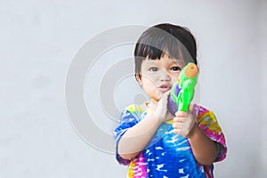 Asian little child girl having fun to play water with water gun in Songkran festival Thailand