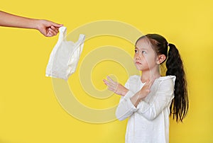 Asian little child girl needless a white thin polythene plastic bag with making X sign her arms for Reduce or zero waste isolated