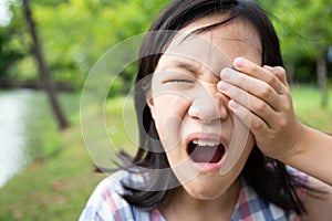 Asian little child girl patient painful,sore eyes,touching,covering with hand or rubbing her eye,feeling eyes pain,female have