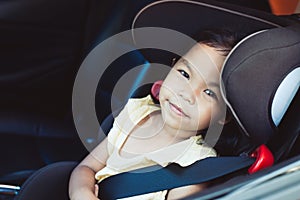 Asian little child girl smiling and sitting in the car seat