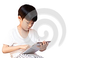 Asian little child using tablet isolated on white background. A boy playing game and learning on a digital tablet photo