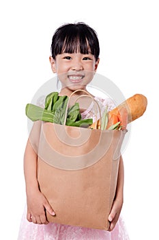 Asian little chinese girl carrying shopping bag with groceries