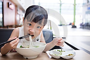 Asian little Chinese girl eating beef noodles soup