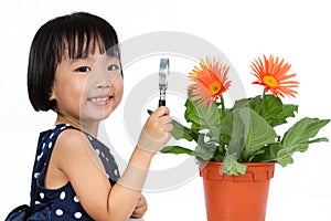 Asian Little Chinese Girl Looking at Flower through a Magnifying