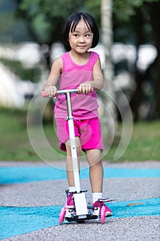 Asian little Chinese girl playing with scooter