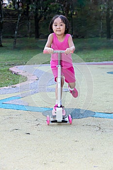 Asian little Chinese girl playing with scooter