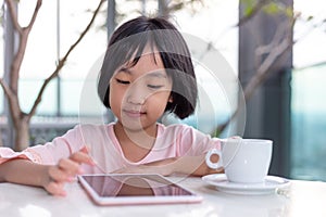 Asian Little Chinese Girl playing with tablet