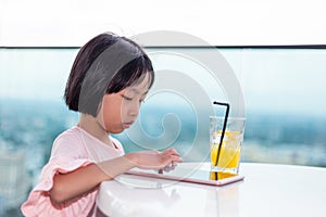 Asian Little Chinese Girl playing with tablet